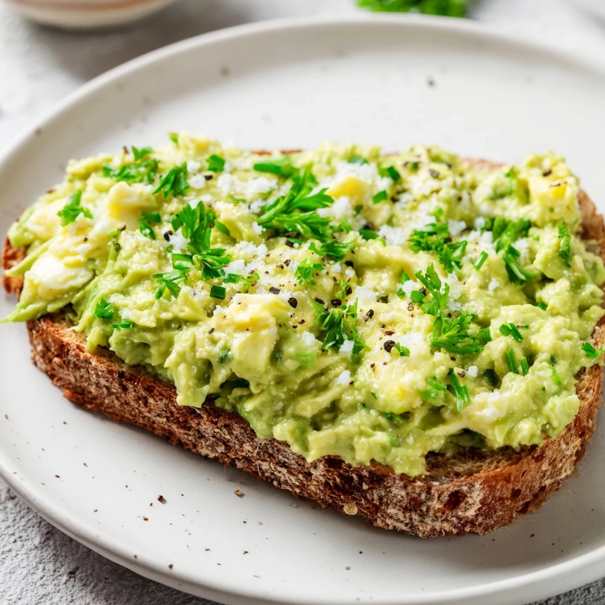 Creamy avocado egg smash on toasted bread, a bright and flavorful American breakfast.
