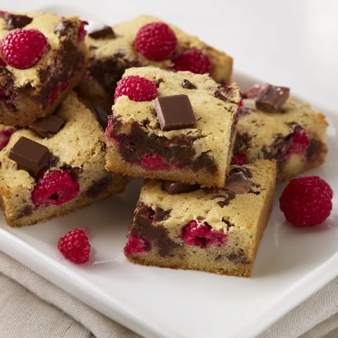 Freshly baked American Decadent White Chocolate and Raspberry Blondies with melted white chocolate and soft raspberries.