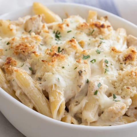 A close-up of bubbling Chicken Ranch Pasta Bake fresh from the oven, garnished with chives and served hot.  