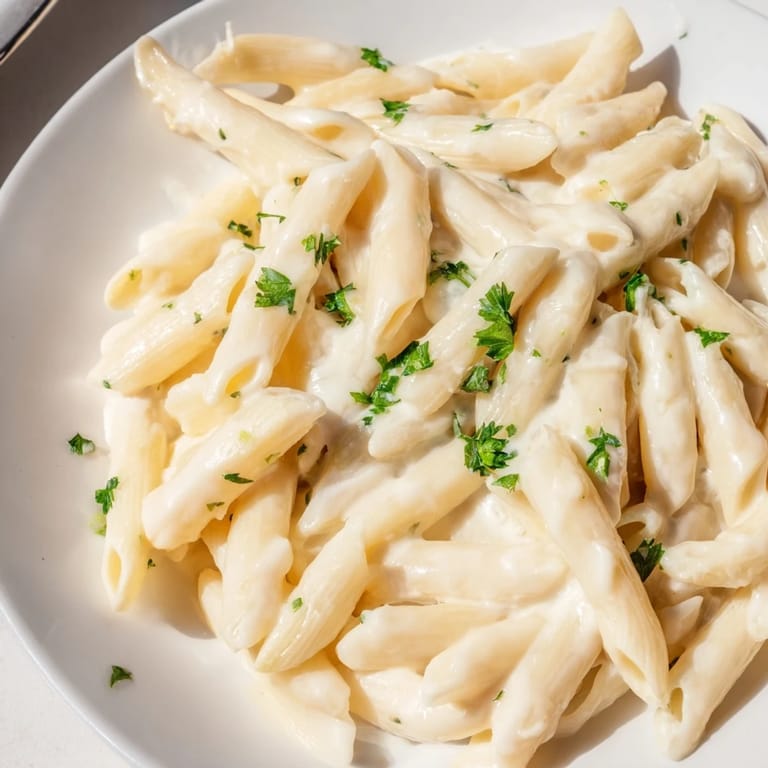 A cozy bowl of Creamy Milk Pasta One-Pot served with garlic bread and a crisp green salad.
